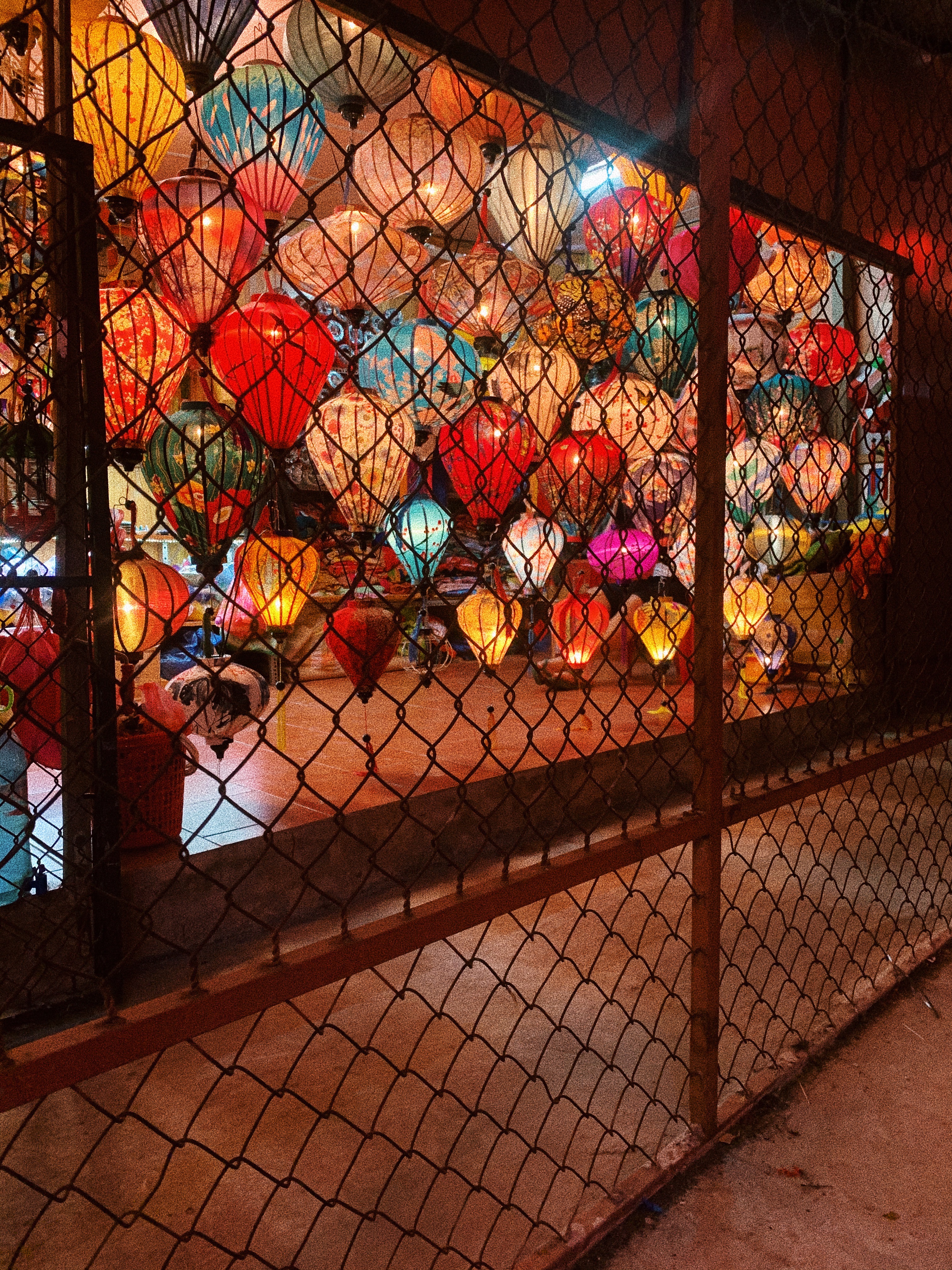 Lanterns in a store behind a fence in Hội An, Vietnam